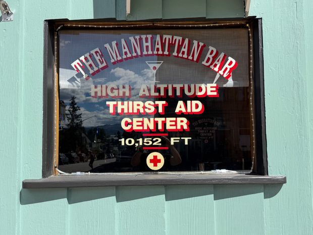 The Manhattan Bar window advertising a high-altitude thirst aid center at 10,152 feet