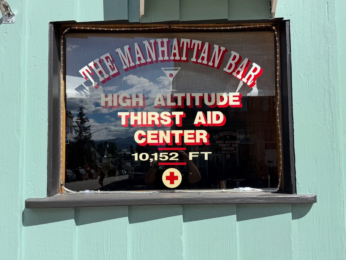 The Manhattan Bar window advertising a high-altitude thirst aid center at 10,152 feet